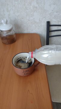 Close-up morning video of milk being poured into a large mug of chicory coffee. Cozy homemade drink, calm breakfast ritual, soft natural light and authentic everyday routine.
