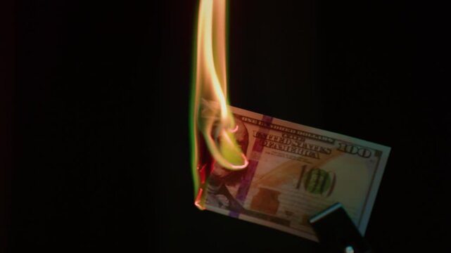 Fire money. Burning 100 bill. Hundred bucks goes up in flames. Collapse of dollar and democracy. End of capitalism, Economic crisis. Burn usd crash. Ignite American paper currency, banknotes.