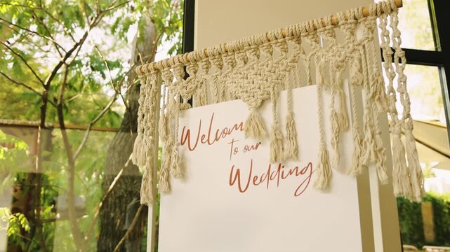 Wedding welcome text lettering push in close up on a handwritten typography message sign board. Slow motion camera moving forward to an elegant calligraphy marriage ceremony greeting banner.