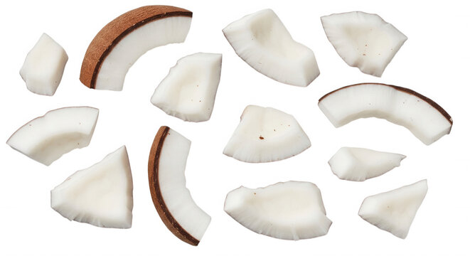 Scattered fresh coconut chunks and curved slices with white meat and brown shell isolated on a black background