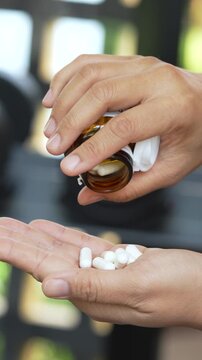 close up woman hand holding a medicine, with pours the pills out of the medicine bottle. Stop drug use Taking Medication Caring for the health care medical concept. capsule.	
