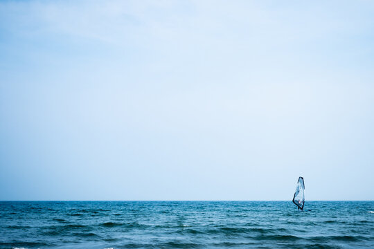 minimal seascape with a lone windsurfer