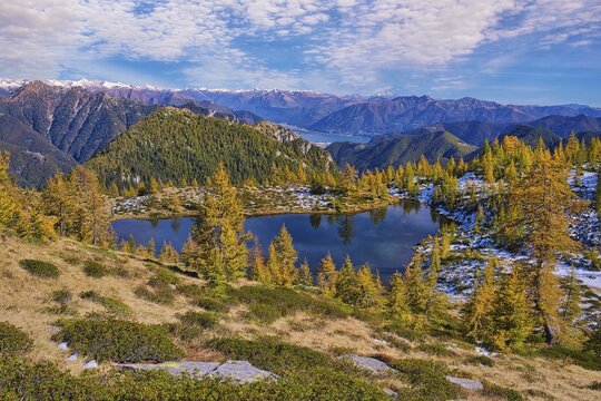 Mountain lake surrounded by autumnal larches, Alpe Salei, Tal Onsernone, Canton Ticino, Switzerland