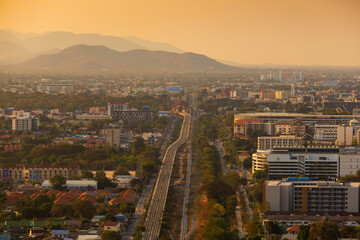 Obraz premium Aerial view of a sprawling city with mountains in the background during golden hour