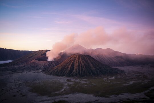 Volcanic landscape at sunrise, smoking volcano Gunung Bromo, with Mt. Batok, Mt. Kursi, Mt. Gunung Semeru, Bromo-Tengger-Semeru National Park, Java, Indonesia