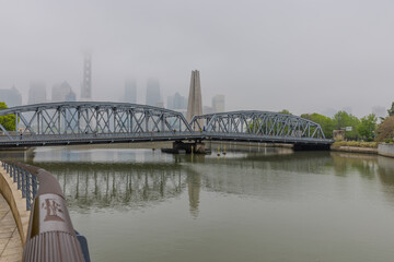 Fototapeta premium Cloudy cold and foggy morning with visibility low of the commercial Buildings on The Bund in Shanghai China on the Huangpu River