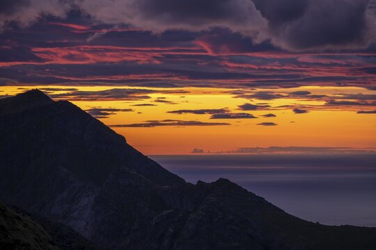 Glowing evening sky over mountain tops, evening glow, dramatic evening mood, sunset with clouds over the sea, view from the top of Hermannsdalstinden, Moskenes&ouml;y, Lofoten, Nordland, Norway