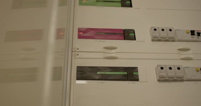 Close up view of various electrical components and indicators on a clean white control panel surface