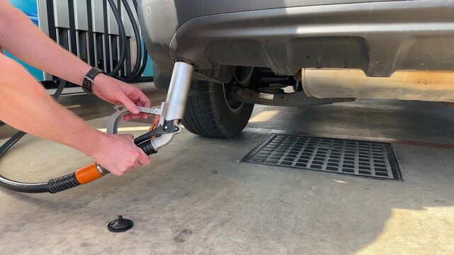 A man disconnect a gas hose after filling a car with gas through an adapter. Closeup. 4k