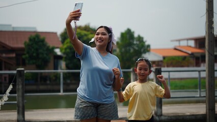 Obraz premium Mother and daughter enjoying time together, making a selfie outdoors