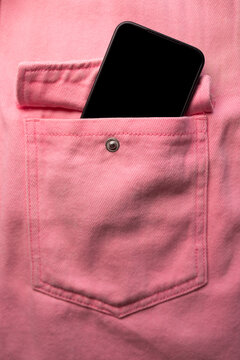 Close-up of a jeans pocket with a pink sticker sticking out of the pocket
