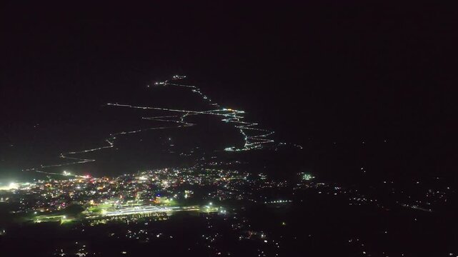 Night aerial orbit of illuminated Vaishno Devi trek in Trikuta hills, Katra, Jammu, India