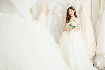 Fototapeta premium Beautiful Bride Holding Bouquet in Bridal Boutique