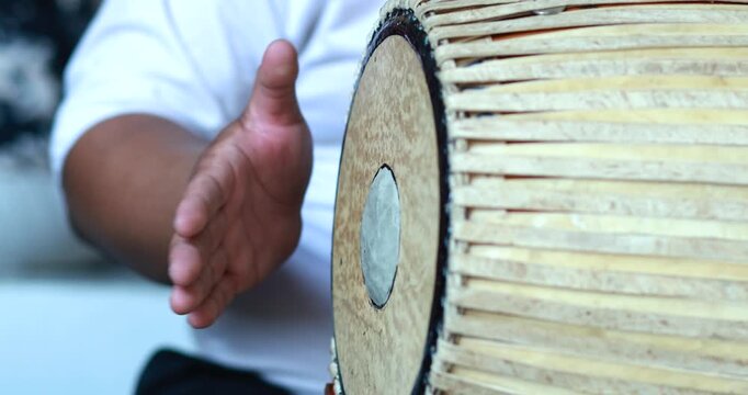 Hands playing traditional Thai drum with rhythmic motion, close-up. Ideal for culture, music, performance, festival, and traditional art concepts