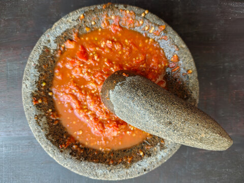 Fresh Indonesian sambal chili paste freshly ground in a traditional stone mortar and pestle