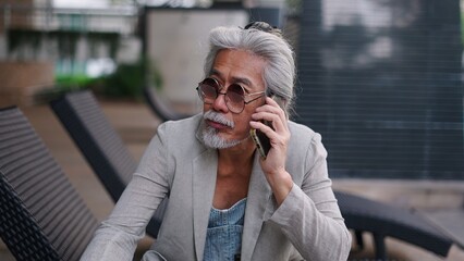 Fototapeta premium Senior asian man talking on smartphone, communicating, connecting while relaxing