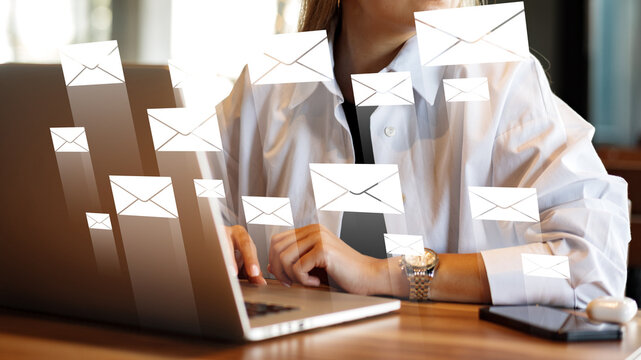 Sending and receiving emails while working on a laptop in a busy office setting