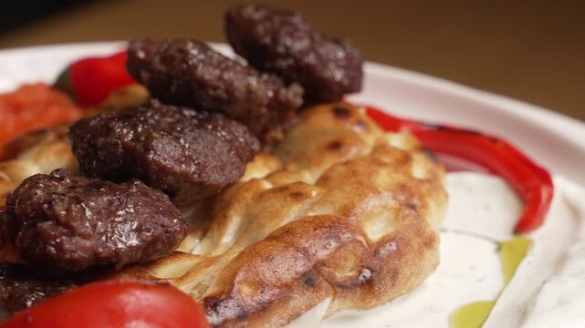Delicious plate of Turkish kofta kebab served with pita bread, tomato, pepper, and yogurt sauce, fa01