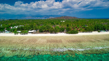 Stunning overhead shot of Gili Trawangan coastline under clear blue sky with crystal clear ocean, coral reefs, and tropical island landscape © jovannig