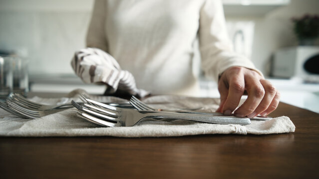 Woman Wipes Forks And Places Them On Towel