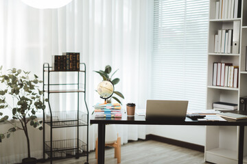 Fototapeta premium Workspace in a modern home office with laptop, documents, and an earth globe on a dark desk, representing global business communication and remote work productivity
