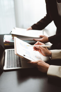 Business professionals analyzing financial reports, planning corporate strategy, discussing market data, and collaborating on economic growth initiatives in an modern office setting