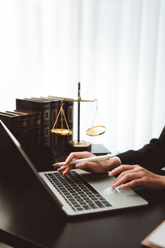 Legal professional using laptop for law research and online consults at office desk, concept of justice, digital legal services, and modern law practice