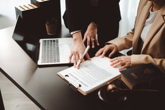 People discussing a contract agreement in a business meeting, reviewing legal documents with an attorney, offering professional advice and signing paperwork