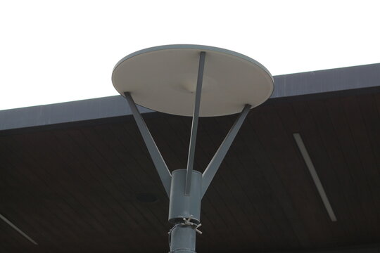 Modern outdoor lamp post with a circular shade and sleek metal design