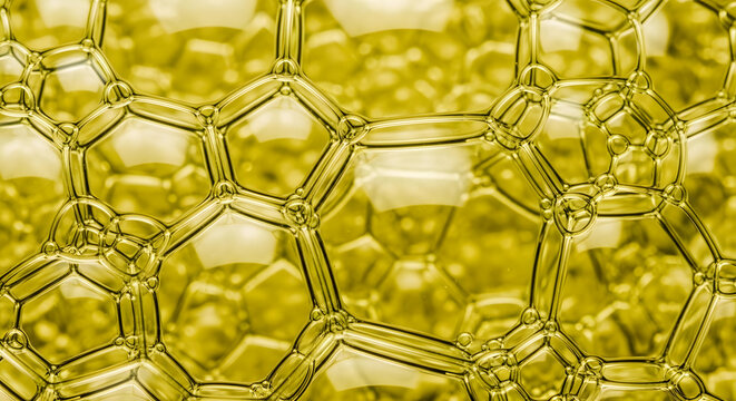 Golden oil droplets macro texture abstract honeycomb pattern background