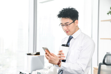 Fototapeta premium Businessman Using Smartphone and Coffee in Office