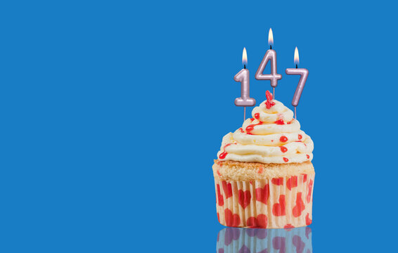 Birthday Or Anniversary Cupcake With Lit Candles; Candles Forming The Number 147