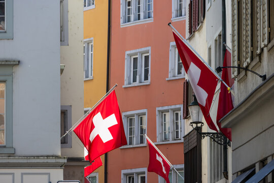 Swiss flags hanging on colorful old town buildings in Zurich