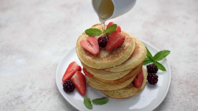 Pouring maple syrup on a delicious pancakes stack