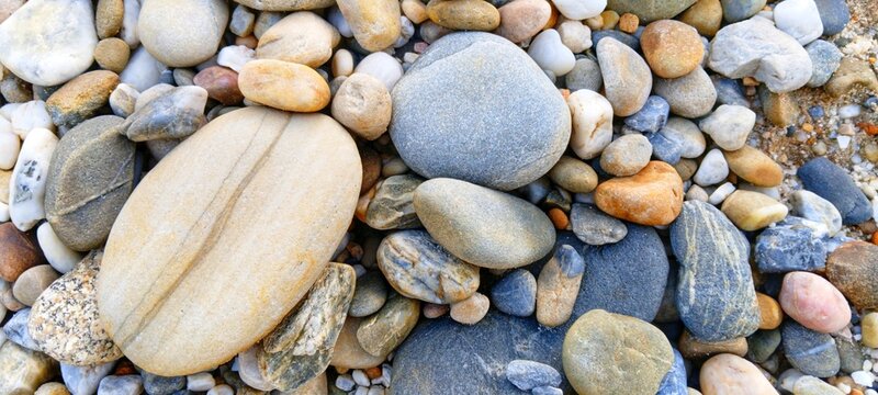 Smooth river pebbles interspersed with fresh green moss. Beautiful contrast of stone and plants, perfect for environmental conservation, sustainability, and eco-friendly branding