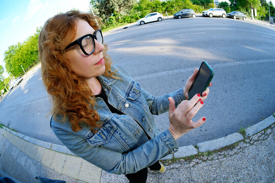 Woman using smartphone outdoors on city street