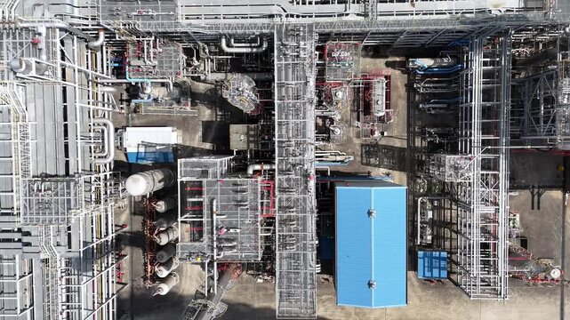 Aerial drone footage of a large petrochemical plant with complex industrial piping and processing facilities.
