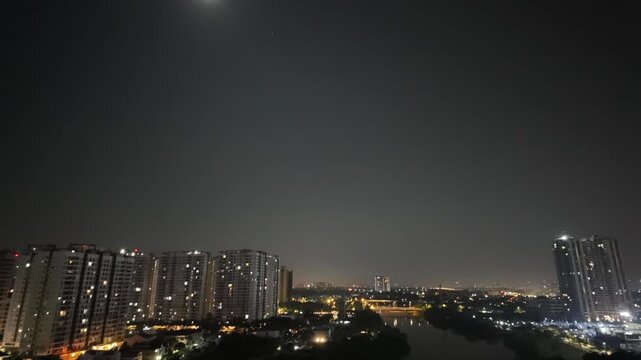 Timelapse footage of a city skyline transitioning from night to dawn with glowing urban lights.