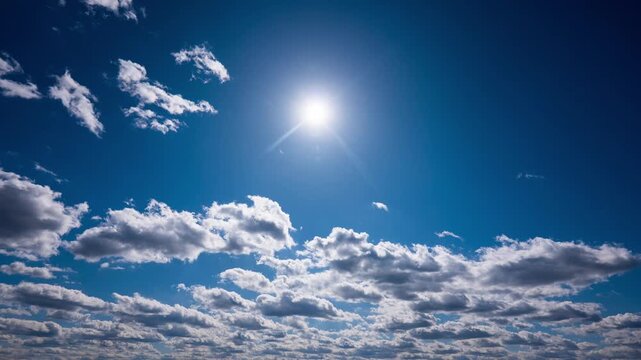 Fluffy white cumulus clouds race across a vibrant blue daytime sky in accelerated motion. Concept of passing time, changing weather patterns, atmosphere dynamics, and clean air.