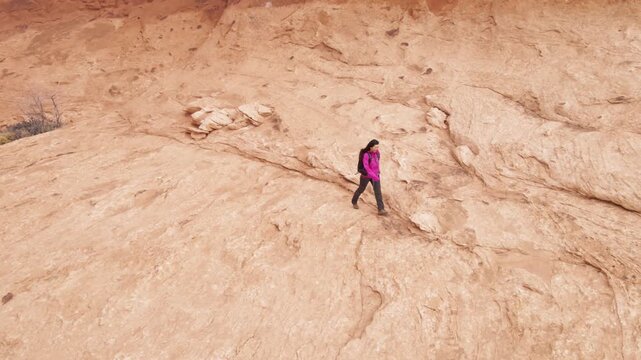 Aerial shot of an Asian woman hiking through the amazing landscape near Moab Utah, USA.