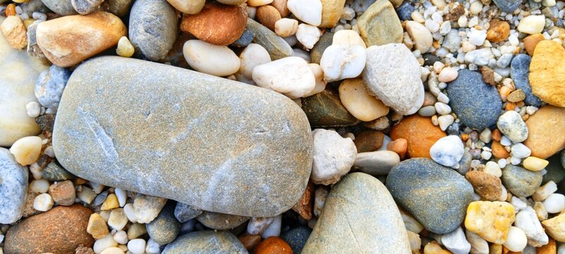 Seamless texture of diverse river pebbles. A natural pattern of mixed shapes and sizes, ideal for website backgrounds, presentations, and graphic design assets