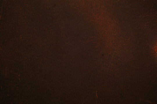 Close up of dark brown leather surface with subtle scratches and texture for backgrounds