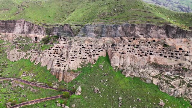 Wide aerial view of Vardzia cave monastery complex and Mtkvari River canyon, Georgia