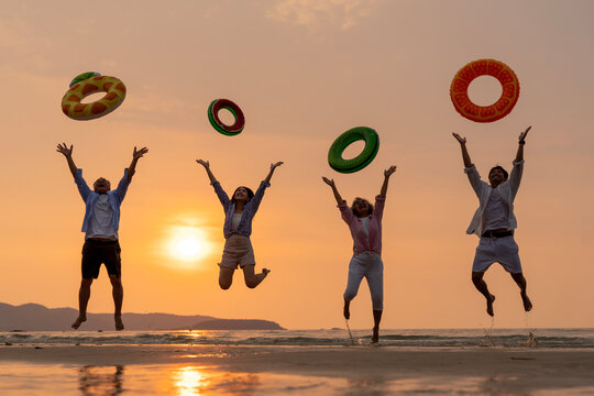 Golden Happiness: Joyful Multi-generational Family Jumping on the Beach at Sunset