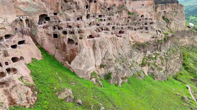 Drone Vardzia cave monastery in Georgia. Aerial side view of the massive rock-hewn historical complex showing multi-layered medieval rooms and pathways carved into the cliff