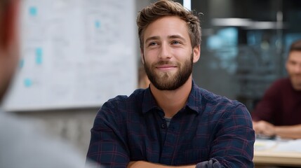 Fototapeta premium A confident man in a plaid shirt poses in a bright modern indoor setting conveying a feeling of professionalism and success