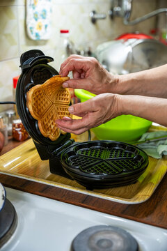 The hostess prepares the cakes heart waffle,old-fashioned way, using traditional European cuisine and utensils.