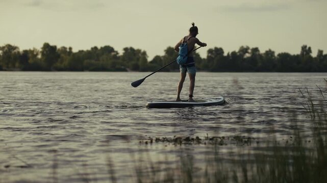 Surfer Paddleboarding On River At Sunset. Balance On Stand Up Paddleboard. Surfing Practice