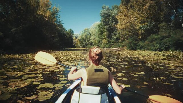 Kayaker with Water Lilies. Kayaking on Scenic Lake.  Outdoor Adventure and Summer Weekend Leisure