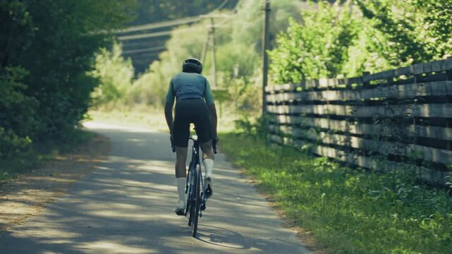 Cyclist Riding Road Bike on Rural Asphalt Path. Athlete Training for Cycling Competition 